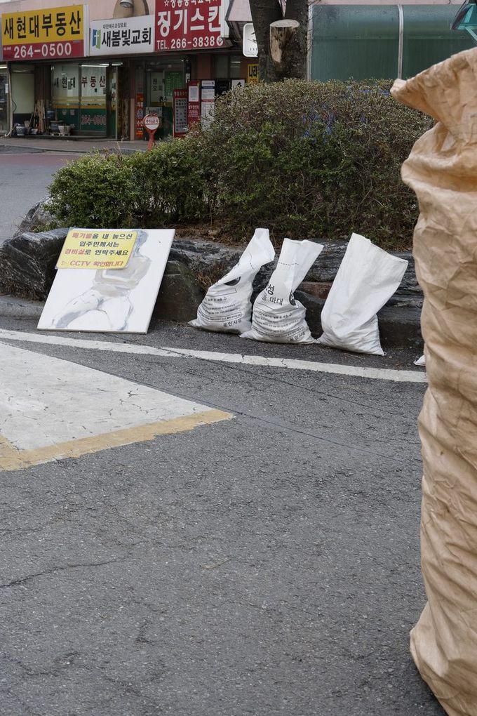 The painting left on the street among garbage bags